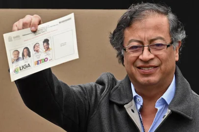 Colombian left-wing presidential candidate Gustavo Petro shows his ballot as he votes during the presidential runoff election in Bogota, on June 19, 2022. - Colombians vote for a new president in an election filled with uncertainty, as former guerrilla Gustavo Petro and millionaire businessman Rodolfo Hernandez vie for power in a country saddled with widespread poverty, violence and other woes. (Photo by Juan BARRETO / AFP)<!-- NICAID(15127462) -->