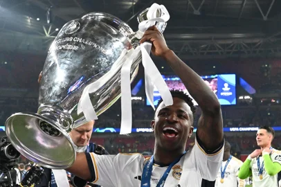 Real Madrid's Brazilian forward #07 Vinicius Junior poses with the trophy to celebrate the victory at the end of the UEFA Champions League final football match between Borussia Dortmund and Real Madrid, at Wembley stadium, in London, on June 1, 2024. (Photo by Glyn KIRK / AFP)<!-- NICAID(15778663) -->