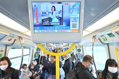 People watch a screen on a train showing news about Hong Kong model and influencer Abby Choi on February 27, 2023 in Hong Kong. - Choi's partial remains were found by the police at a house on February 24. Hong Kong police have made four arrests for the murder and dismemberment of the 28-year-old model after a financial dispute with her ex-husband's family, authorities said. (Photo by Peter PARKS / AFP)<!-- NICAID(15360455) -->