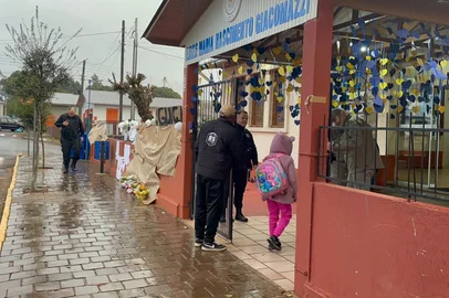 O abraço dos professores, zelador e policiais recepciona os estudantes que retornam à Escola Maria Nascimento Giacomazzi, em Estação, pela primeira vez desde o ataque do dia 8 de julho.<!-- NICAID(16082195) -->