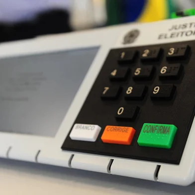 GARIBALDI, RS, BRASIL, 24/03/2022. Justiça eleitoral realiza auditoria de urnas eletrônicas antes das eleições suplementares de Garibaldi. Também foi apresentado o novo modelo de urna eletrônica. Coordenador de Tecnologia do TSE Rafael Azevedo (camisa clara) e Vanderlei Santos (de terno escuro), coordenador de urnas do TRE, foram os responsávies pela apresentação. (Porthus Junior/Agência RBS)<!-- NICAID(15050242) -->