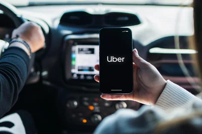 Girl inside car holding smartphone with Uber app on screen. Rio de Janeiro, RJ, Brazil. August 2022.Fonte: 525383591<!-- NICAID(15541625) -->