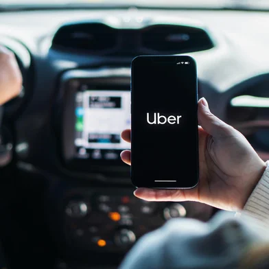 Girl inside car holding smartphone with Uber app on screen. Rio de Janeiro, RJ, Brazil. August 2022.Fonte: 525383591<!-- NICAID(15541625) -->