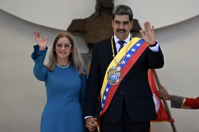 (FILES) Venezuela's President Nicolas Maduro and his wife Cilia Flores wave to supporters as they leave the Capitolio -home of the National Assembly- after taking the oath during the presidential inauguration in Caracas on January 10, 2025. Venezuelan President Nicolas Maduro and his wife, Cilia Flores, were seized by US forces during a pre-dawn raid on January 3, 2026, in Caracas and taken to New York to face charges of "narcoterrorism." Deposed Maduro is scheduled to appear before a federal judge in New York at noon on January 5, to be formally notified about the charges against him, the court said. (Photo by Juan BARRETO / AFP)Editoria: POLLocal: CaracasIndexador: JUAN BARRETOSecao: politics (general)Fonte: AFPFotógrafo: STF<!-- NICAID(16199008) -->