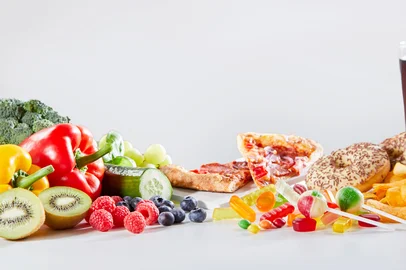 Table covered in assorted food and drinks including croissants and bell peppers next to glasses of juice<!-- NICAID(16196867) -->