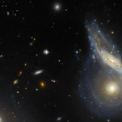 This NASA/ESA Hubble Space Telescope image features Arp 122, a peculiar galaxy that in fact comprises two galaxies – NGC 6040, the tilted, warped spiral galaxy and LEDA 59642, the round, face-on spiral – that are in the midst of a collision. This dramatic cosmic encounter is located at the very safe distance of roughly 570 million light-years from Earth. Peeking in at the lower-left corner is the elliptical galaxy NGC 6041, a central member of the galaxy cluster that Arp 122 resides in, but otherwise not participating in this monster merger.<!-- NICAID(15650958) -->