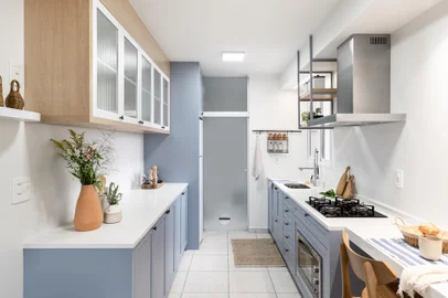 Momento de renovaçãoReforma completa de cozinha traz mais luz e funcionalidade ao espaço de apenas 10 metros quadrados Marcenaria: protagonista do projeto, o mobiliário, em tom de azul, agrega cores e elementos afetivos. Portas e gavetas com puxadores do tipo ponto. O aéreo, com acabamento carvalho, tem portas com vidro canelado para mais suavidade. A abertura em gesso acartonado funcionou como um viga falsa para a agem do duto da coifa e distribuição de novos pontos de iluminação sobre as bancadas<!-- NICAID(15632030) -->
