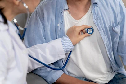 Doctor using stethoscope to check patientâ€™s breathing â€“ medical examination and carePhysician listening to patientâs breath sounds with stethoscope during routine health checkup.Fonte: 1548025069<!-- NICAID(16144389) -->