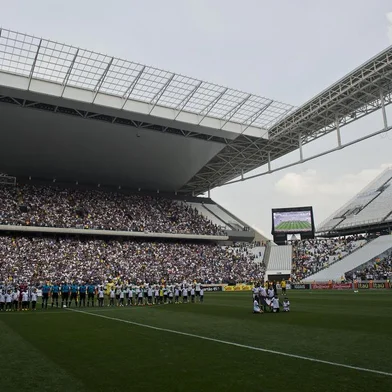 Football players line up before the Brazilian championship football match between Corinthians and Figueirense as part of the official inauguration of the Arena de Sao Paulo stadium, on May 18, 2014, in Sao Paulo, Brazil. The Arena de Sao Paulo, of Brazilian team Corinthians, will host the opening match of the Brazil 2014 FIFA World Cup between Brazil and Croatia on June 12. AFP PHOTO / NELSON ALMEIDA<!-- NICAID(10502429) -->