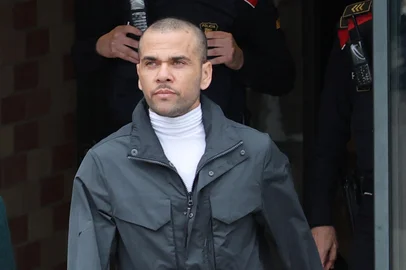 Convicted rapist and former Brazil international football player Dani Alves (R) leaves on provisional release, flanked by his lawyers Ines Guardiola, at Brians 2 prison in Barcelona on March 25, 2024. Convicted rapist and former Brazil international Dani Alves left a jail in Barcelona on March 25, 2024 after posting the one-million-euro bail set by a Barcelona court to ensure his release pending appeal. Ex-Brazil star has been sentenced to 4.5 years in jail for rape on February 22, 2024. (Photo by LLUIS GENE / AFP)<!-- NICAID(15715255) -->
