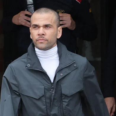 Convicted rapist and former Brazil international football player Dani Alves (R) leaves on provisional release, flanked by his lawyers Ines Guardiola, at Brians 2 prison in Barcelona on March 25, 2024. Convicted rapist and former Brazil international Dani Alves left a jail in Barcelona on March 25, 2024 after posting the one-million-euro bail set by a Barcelona court to ensure his release pending appeal. Ex-Brazil star has been sentenced to 4.5 years in jail for rape on February 22, 2024. (Photo by LLUIS GENE / AFP)<!-- NICAID(15715255) -->