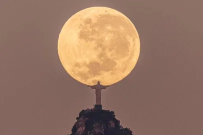 Fotografia que pelo enquadramento simula que o Cristo Redentor está segurando a Lua. Trabalho realizado pelo fotógrafo carioca Leonardo Sens<!-- NICAID(15451360) -->