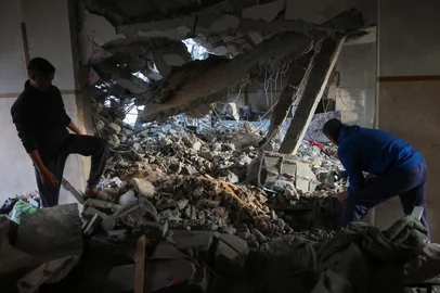 People look through the rubble in a school-turned-camp after an Israeli strike in Gaza City on March 18, 2025. Israel on March 18 unleashed its most intense campaign on the Gaza Strip since a January ceasefire, with Gaza civil defence agency saying 220 people killed, prompting Hamas to accuse Benjamin Netanyahu's government of torpedoing the truce. (Photo by Omar AL-QATTAA / AFP)<!-- NICAID(15997751) -->
