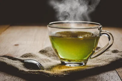 Close-up a cup of green tea on sackcloth, hot drink with steamFonte: 218383251<!-- NICAID(15537064) -->