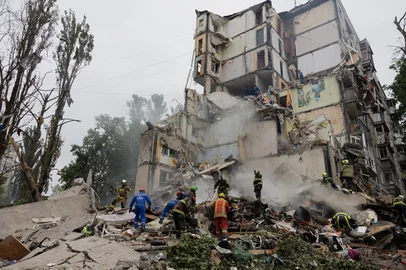 Rescuers clear debris as they work at the site of a destroyed residential building following a Russian air attack in Kyiv on July 31, 2025, amid the Russian invasion of Ukraine. (Photo by Tetiana DZHAFAROVA / AFP)<!-- NICAID(16091458) -->