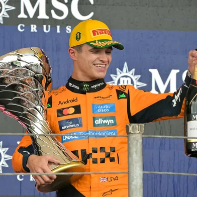 McLaren's British driver Lando Norris celebrates with the trophy and champagne after winning the Sao Paulo Formula One Grand Prix at the Jose Carlos Pace racetrack, aka Interlagos, in Sao Paulo, Brazil on November 9, 2025. (Photo by Nelson ALMEIDA / AFP)<!-- NICAID(16168659) -->