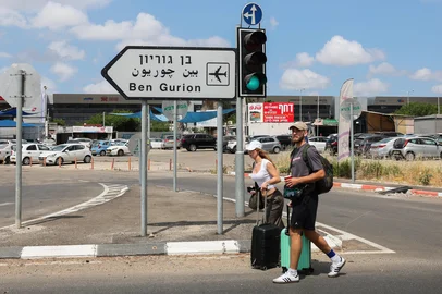 Travelers pull their luggage as they walk towards Ben Gurion airport after main road entrances to the facility were closed by Israeli Police, following air defence activation against a missile launched from Yemen on May 4, 2025. "Several attempts were made to intercept the missile launched from Yemen. A fall was identified in the area of Ben Gurion airport," a military statement said on May 4 without specifying what fell, while adding "the incident is under review". (Photo by Jack GUEZ / AFP)<!-- NICAID(16029428) -->