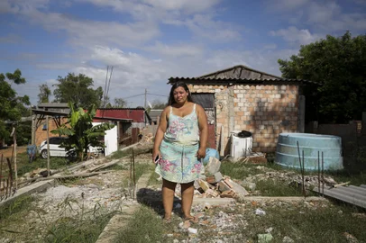 Eldorado do Sul, RS, Brasil, 07-03-2024:  Lisiane da Silva Ramos no espaço em que pretende erguer sua nova casa, nos fundos da casa onde mora, no bairro Itaí, em Eldorado do Sul. O terreno foi atingido pela enchente e ela recebeu recursos do programa Volta por Cima, do governo estadual, com os quais adquiriu material de construção e planeja investir na nova moradia, no mesmo local. Foto: Mateus Bruxel / Agência RBSIndexador: Mateus Bruxel<!-- NICAID(15699095) -->