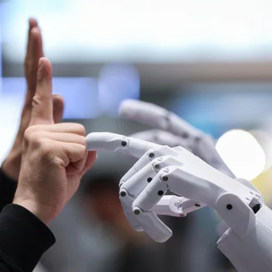 A man interacts with PIB (Printable Intelligent Bot), a 3D printable humanoid robot, at the booth of German Federal Ministry of Education and Research during the opening of the Hannover Messe industrial trade fair for mechanical and electrical engineering and digital industries, on March 31, 2025 in Hanover, northern Germany. The fair opens its doors to the public on March 31 and will be running until April 4, 2025. According to the Hannover Messe, "more than 4,000 companies will be acting as an interconnected industrial ecosystem and demonstrating how climate neutrality can be achieved through electrification, digitization and automation". (Photo by RONNY HARTMANN / AFP)Editoria: FINLocal: HanoverIndexador: RONNY HARTMANNSecao: industrial productionFonte: AFPFotógrafo: STR<!-- NICAID(16008351) -->