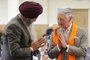 Britain's King Charles III makes the namaste gesture as a traditional shawl for meditation is placed around his shoulders in the Prayer Hall during his visit to the newly built Guru Nanak Gurdwara, in Luton, north of London on December 6, 2022. - The Guru Nanak Gurdwara Luton provides Sikh religious teaching and practice for all members of the community and provides voluntary social services for the elderly, youth and other groups in the community. (Photo by Chris Jackson / POOL / AFP)<!-- NICAID(15287457) -->