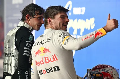 Winner Red Bull Racing's Dutch driver Max Verstappen (R) and third-placed Mercedes' Italian driver Kimi Antonelli celebrate after the Formula One Singapore Grand Prix at the Marina Bay Street Circuit in Singapore on October 11, 2026. (Photo by ANTHONY WALLACE / AFP)<!-- NICAID(16384983) -->