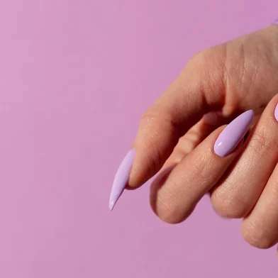 Female hand with a beautiful purple long nails manicure on a lilIndexador: V&A PHOTOFonte: 496670835<!-- NICAID(15504345) -->