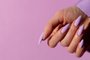 Female hand with a beautiful purple long nails manicure on a lilIndexador: V&A PHOTOFonte: 496670835<!-- NICAID(15504345) -->