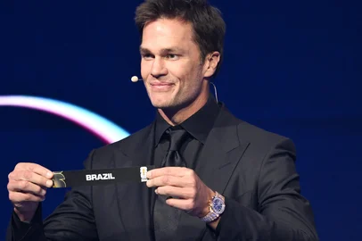 MANDEL NGAN / POOL/AFP US Draw assistant Tom Brady shows the card reading Brazil during the draw for the 2026 FIFA Football World Cup taking place in the US, Canada and Mexico, at the Kennedy Center, in Washington, DC, on December 5, 2025. (Photo by Mandel NGAN / POOL / AFP)<!-- NICAID(16181290) -->