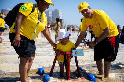 TRAMANDAÍ, RS, BRASIL, 07.01.2024: Sesc em parceria com o projeto Tampinha Legal promove o banho de mar de crianças com deficiências usando protótipos de andadores de plástico.Os equipamentos são resultado da economia circular, reaproveitamento de tubos de PVC. Foto: Camila Hermes/Agencia RBS<!-- NICAID(15643598) -->