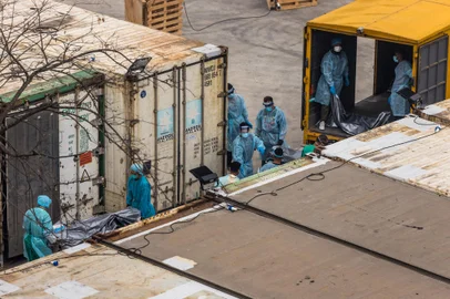 Workers move the bodies of deceased people from a truck into a refrigerated container at the Fu Shan Public Mortuary in Hong Kong on March 16, 2022, amid the city's worst-ever Covid-19 coronavirus outbreak that has seen overflowing hospitals and morgues and a frantic expansion of the city's spartan quarantine camp system. (Photo by DALE DE LA REY / AFP)Editoria: HTHLocal: Hong KongIndexador: DALE DE LA REYSecao: diseaseFonte: AFPFotógrafo: STF<!-- NICAID(15042345) -->