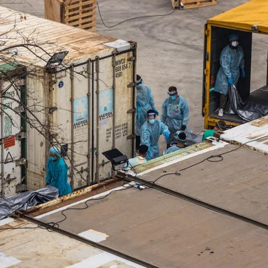 Workers move the bodies of deceased people from a truck into a refrigerated container at the Fu Shan Public Mortuary in Hong Kong on March 16, 2022, amid the city's worst-ever Covid-19 coronavirus outbreak that has seen overflowing hospitals and morgues and a frantic expansion of the city's spartan quarantine camp system. (Photo by DALE DE LA REY / AFP)Editoria: HTHLocal: Hong KongIndexador: DALE DE LA REYSecao: diseaseFonte: AFPFotógrafo: STF<!-- NICAID(15042345) -->