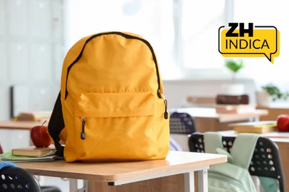 leonid iastremskyi / Pixel-Shot / stock.adobe.com Yellow backpack with apple and copybooks on desk in classroom<!-- NICAID(16206465) -->