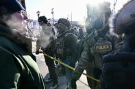 A man speaks to federal agents as demonstrators gather near the site of where state and local authorities say a man was shot by federal agents earlier in the morning in Minneapolis, Minnesota, on January 24, 2026. Minnesota Governor Tim Walz said Saturday that federal agents deployed in Minneapolis as part of a sweeping immigration crackdown had carried out "another horrific shooting," less than three weeks after the fatal shooting of Renee Good. (Photo by ROBERTO SCHMIDT / AFP)<!-- NICAID(16211008) -->