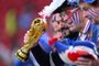 A France supporter carries a replica of the trophy ahead of the Qatar 2022 World Cup semi-final football match between France and Morocco at the Al-Bayt Stadium in Al Khor, north of Doha on December 14, 2022. (Photo by Kirill KUDRYAVTSEV / AFP)<!-- NICAID(15295791) -->