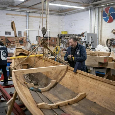 Colin Laycock (R), a Director of The Viking Boat Co., works to put the finishing touches to a replica 30-foot Viking longboat in their workshop in Darlington, north east England on February 13, 2025. Made from solid oak using authentic Scandinavian plans, a Viking longship built by military veterans fighting mental health battles is finally ready after a long labour of love. "It is not about a boat, it's not about wood. We're making boats, but we're actually rebuilding people," Bob Marshall told AFP at the project's workshop in Darlington, northeastern England. The company utilises woodwork and boatbuilding tuition to help ex-military personnel develop mental resilience and coping strategies to counter the effects of PTSD, anxiety, stress, loneliness, and isolation sustained due their service. (Photo by Oli SCARFF / AFP)Editoria: HUMLocal: DarlingtonIndexador: OLI SCARFFSecao: societyFonte: AFPFotógrafo: STF<!-- NICAID(15979546) -->