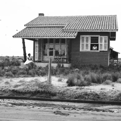 Casa construída por Oscar Boz, de Caxias do Sul, em Xangri-Lá, em 1953. Residência, batizada de "A Pioneira", foi a primeira da praia em formação, na esquinas das ruas Jacuí e Rio Forqueta. Completa 70 anos em setembro de 2023. Na sacada, dona Nair. Na janela, Léa Stutz Boz. À direita, ao fundo, o forno para fazer pão.<!-- NICAID(15327259) -->