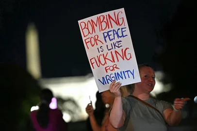A protestor holds a sign at Lafayette Square outside The White House in Washington, DC, on June 21, 2025, following the announcement that the US bombed nuclear sites in Iran and before US President Donald Trump adresses the nation. President Donald Trump said June 21, 2025 the US military has carried out a "very successful attack" on three Iranian nuclear sites, including the underground uranium enrichment facility at Fordo. "We have completed our very successful attack on the three Nuclear sites in Iran, including Fordow, Natanz, and Esfahan," Trump said in a post on his Truth Social platform. Trump says to address the nation at 10 pm (0200 GMT) after US strikes on Iran. (Photo by Mandel NGAN / AFP)Editoria: WARLocal: WashingtonIndexador: MANDEL NGANSecao: armed conflictFonte: AFPFotógrafo: STF<!-- NICAID(16064870) -->