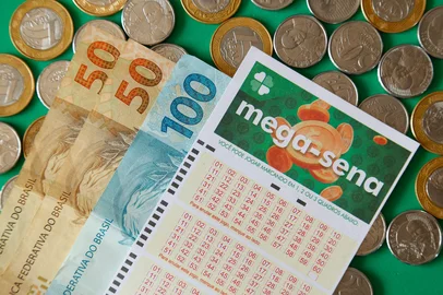 Minas Gerais, Brazil - February 22, 2021: cash notes, coins and lottery ticket Caixa Mega Sena. Foto:  sidneydealmeida/ stock.adobe.comIndexador: sidneydealmeida.comFonte: 416264466Fotógrafo: sidneydealmeida.com<!-- NICAID(16213052) -->