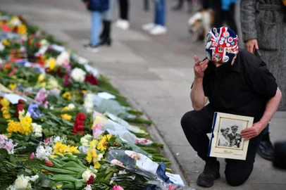 An ardent Royals supporter pays tribute outside Windsor Castle, in Windsor, west of London, on April 9, 2021, following the announcement of the death of Britain's Prince Philip, Duke of Edinburgh. - Prince Philip, the longest serving royal consort in British history who was a constant presence at Queen Elizabeth II's side for decades, died on Friday aged 99, Buckingham Palace announced. (Photo by Ben STANSALL / AFP)Editoria: HUMLocal: WindsorIndexador: BEN STANSALLSecao: imperial and royal mattersFonte: AFPFotógrafo: STF<!-- NICAID(14754435) -->