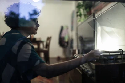 PORTO ALEGRE, RS, BRASIL, 10-10-2025:  Uma pesquisa mostrou que jovens nascidos de 1997 até 2012 têm interesse em uma era pré-digital, mesmo que não tenham a vivido. Paola De Bettio , 25 anos, "herdou" do pai diversos CDs. Pelo menos desde os 15 anos, ela também gosta de câmeras analógicas. Tem vinis e livros físicos e gosta de escrever a mão e desenhar. Ela diz que esse interesse por uma estética mais antiga a faz se aproximar mais do pai, já falecido. Foto: Renan Mattos / Agência RBS<!-- NICAID(16143884) -->