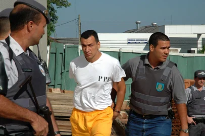 Marcos Camacho, o Marcola (c), chega escoltado ao Fórum da comarca de Presidente Prudente (SP), em 07/11/2005. Conversas telefônicas entre detentos de penitenciárias da região noroeste do Estado, grampeadas pelo Departamento de Polícia do Interior (Deinter-5) identificaram que a ordem dos ataques a PMs foi dada por Marcola, que é líder do PCC. Fonte: AE Fotógrafo: JORGE SANTOS<!-- NICAID(1070906) -->