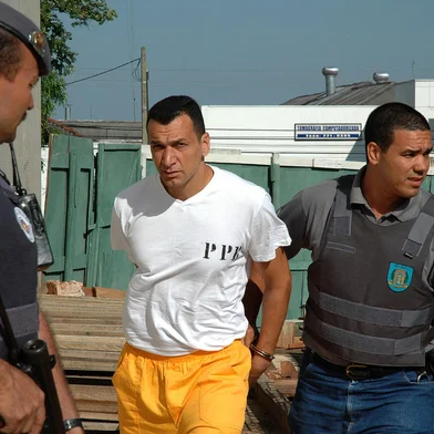 Marcos Camacho, o Marcola (c), chega escoltado ao Fórum da comarca de Presidente Prudente (SP), em 07/11/2005. Conversas telefônicas entre detentos de penitenciárias da região noroeste do Estado, grampeadas pelo Departamento de Polícia do Interior (Deinter-5) identificaram que a ordem dos ataques a PMs foi dada por Marcola, que é líder do PCC. Fonte: AE Fotógrafo: JORGE SANTOS<!-- NICAID(1070906) -->