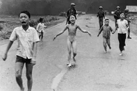 Vietnã, 08/06/1972: Nesta sexta-feira (16), a World Press Photo anunciou a suspensão da atribuição de autoria da fotografia ‘The Terror of War’, imagem vencedora do prêmio de Foto do Ano de 1973. A decisão vem após uma investigação conduzida entre janeiro e maio de 2025, motivada pelo documentário The Stringer, da The VII Foundation que estreou no Sundance Film Festival, e que acabou por colocar em dúvida a autoria do fotógrafo Nick Út, da Associated Press.A foto — que mostra crianças vietnamitas fugindo de um ataque de napalm, incluindo a icônica figura de Kim Phuc, nua e ferida — é uma das imagens mais reconhecidas da história do fotojornalismo. Por décadas, ela foi atribuída a Nick Út, que inclusive recebeu o Prêmio Pulitzer pelo trabalho.No entanto, a análise técnica feita sob supervisão da World Press Photo, considerando posição geográfica, distância do ponto de captura e o tipo de câmera utilizada, apontou que outros dois fotógrafos vietnamitas que estavam presentes — Nguyễn Thành Nghệ e Huỳnh Công Phúc — poderiam ter estado melhor posicionados para realizar o registro. A organização reforça que a validade histórica e jornalística da fotografia permanece intacta. O que está suspenso, por ora, é apenas a autoria atribuída a Nick Út, até que surjam provas conclusivas. A entidade reconhece que essa pode ser uma questão sem resolução definitiva — uma das muitas “histórias contestadas” que fazem parte do próprio ofício do jornalismo visual.Os detalhes completos da investigação serão apresentados neste sábado, 17 de maio, durante o evento “The Stories That Matter”, às 15h (horário local), na De Nieuwe Kerk, em Amsterdã, seguido de uma sessão de perguntas com a diretora da instituição. Foto: AP/Divulgação World Press Photo<!-- NICAID(16038787) -->