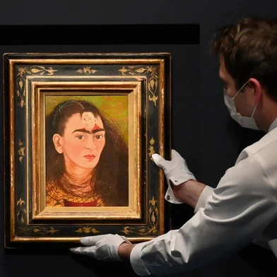 An art handler adjusts Frida Kahlo's final "Bust" Self-Portrait 'Diego y yo" (Diego and I) at Sotheby's on November 5, 2021 in New York City. - After more than a year, in-person auctions are returning to New York this week with the sale of the exceptional Macklowe collection, reputed to be the most expensive in the world to come onto the market -- and buyers are champing at the bit after the pandemic.At renowned auction houses Christie's and Sotheby's, the message is the same: the art market is doing very well.With fall sales estimated to bring in more than $1 billion in a week, starting on November 15, "this is our largest sale season that we've presented since 2015," a record year, said Brooke Lampley, president of the fine arts department at Sotheby's. (Photo by ANGELA WEISS / AFP) / RESTRICTED TO EDITORIAL USE - MANDATORY MENTION OF THE ARTIST UPON PUBLICATION - TO ILLUSTRATE THE EVENT AS SPECIFIED IN THE CAPTION<!-- NICAID(14942887) -->
