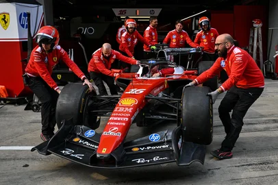 Team members move the car of Ferrari's Monegasque driver Charles Leclerc ahead of the Formula One Chinese Grand Prix at the Shanghai International Circuit in Shanghai on March 12, 2026. (Photo by Hector RETAMAL / AFP)<!-- NICAID(16243928) -->