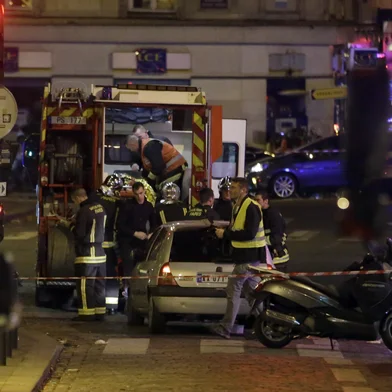 Ambulance workers are seen at the scene in the 10th arrondissement of the French capital Paris, following a string of attacks, on November 13, 2015. At least 18 people were killed as multiple shootings and explosions hit Paris, police said. Police also said there was an ongoing hostage crisis in the Bataclan a concert hall in the French capital. AFP PHOTO / KENZO TRIBOUILLARD