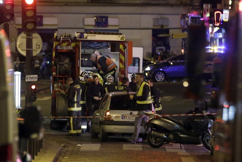 Ambulance workers are seen at the scene in the 10th arrondissement of the French capital Paris, following a string of attacks, on November 13, 2015. At least 18 people were killed as multiple shootings and explosions hit Paris, police said. Police also said there was an ongoing hostage crisis in the Bataclan a concert hall in the French capital. AFP PHOTO / KENZO TRIBOUILLARD