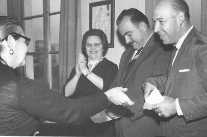 Solenidade escolar com a presença da professora Ester Troian Benvenutti (ao fundo, de óculos), o prefeito Armando Biazus (ao centro) e o professor e radialista Nestor Gollo (à direita)<!-- NICAID(11237037) -->