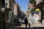 A woman and a child walk as a man rides a bycicle along a street at the Villa 21-24 shantytown in Buenos Aires on September 29, 2020, amid the new coronavirus pandemic. - Argentina's economy contracted 12.6% in the first seven months of 2020 compared to the same period last year, in the midst of the covid-19 pandemic, the state-run statistics institute INDEC reported Monday. (Photo by RONALDO SCHEMIDT / AFP)