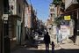 A woman and a child walk as a man rides a bycicle along a street at the Villa 21-24 shantytown in Buenos Aires on September 29, 2020, amid the new coronavirus pandemic. - Argentina's economy contracted 12.6% in the first seven months of 2020 compared to the same period last year, in the midst of the covid-19 pandemic, the state-run statistics institute INDEC reported Monday. (Photo by RONALDO SCHEMIDT / AFP)